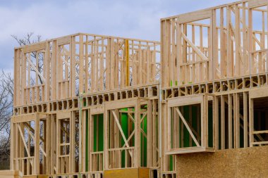 new residential construction home framing home against a blue sky plywood wooden plank wall real