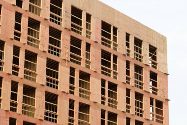 new apartment building under construction plywood facade wall