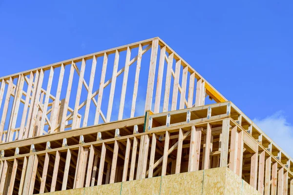 closeup new stick built home under construction under blue sky framing structure wood frame of wooden houses home house construction tall log plank
