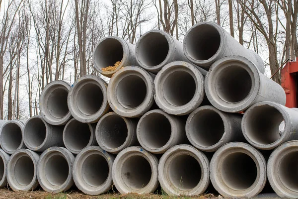 large concrete sewer pipes up on the ground cement stack gray