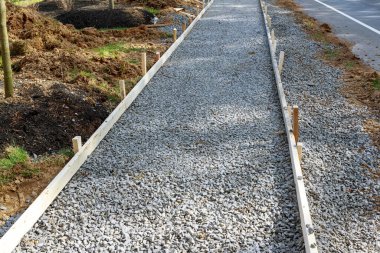 Kaldırımda yeni beton zemin üzerinde çalışmalar ve çakıllar.