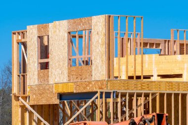 Mavi gökyüzü ahşap inşaat ahşap duvar kirişine karşı çerçevelenmiş yeni bir iskan evi.