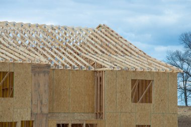 rafters and plywood walls of a new house plank site clipart