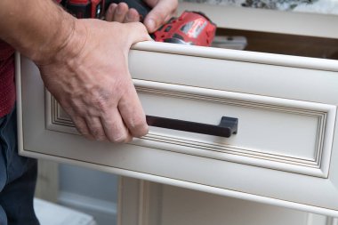 Mutfak dolabında yeni bir tornavida işçisiyle el ele kurulum kapısı.