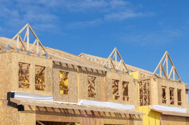 Yeni bir kontrplak ev ahşap çatı iskeletinin duvarları ve kirişleri.