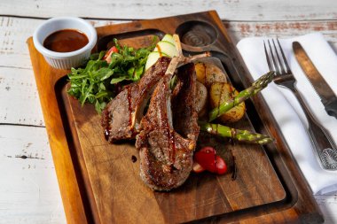 Kuzu pirzola ve et sosu pişiyor.