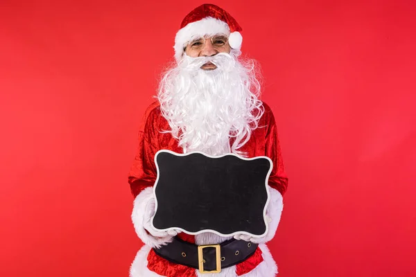 一个人穿着圣诞老人的衣服 拿着黑色的标志 背景是红色的 圣诞节 消费主义和幸福概念 — 图库照片