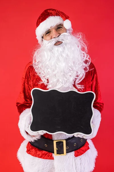 Man Klädd Som Jultomten Håller Svart Skylt Röd Bakgrund Jul — Stockfoto