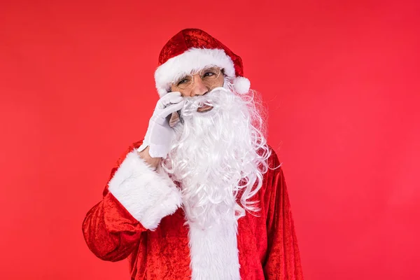 男人穿得像圣诞老人 在手机上用红色背景说话 圣诞节 消费主义和幸福概念 — 图库照片