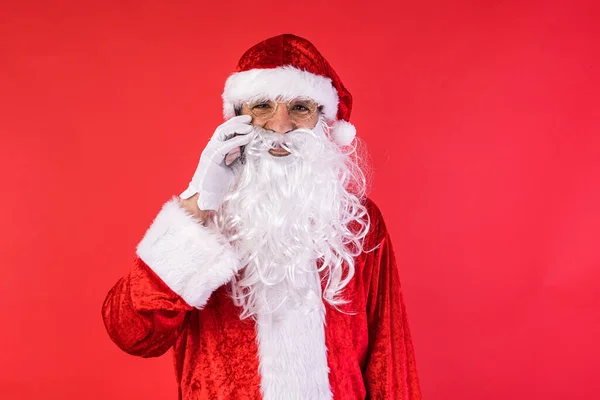 Człowiek Przebrany Świętego Mikołaja Rozmawiający Przez Komórkę Czerwonym Tle Boże — Zdjęcie stockowe