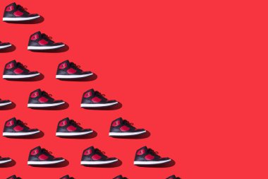 Pattern of NIKE Jordan Access sneakers in black and red, on the left side, on a red background. Concept of sneaker, basketball, retro, michael jordan, fashion, collection and casual
