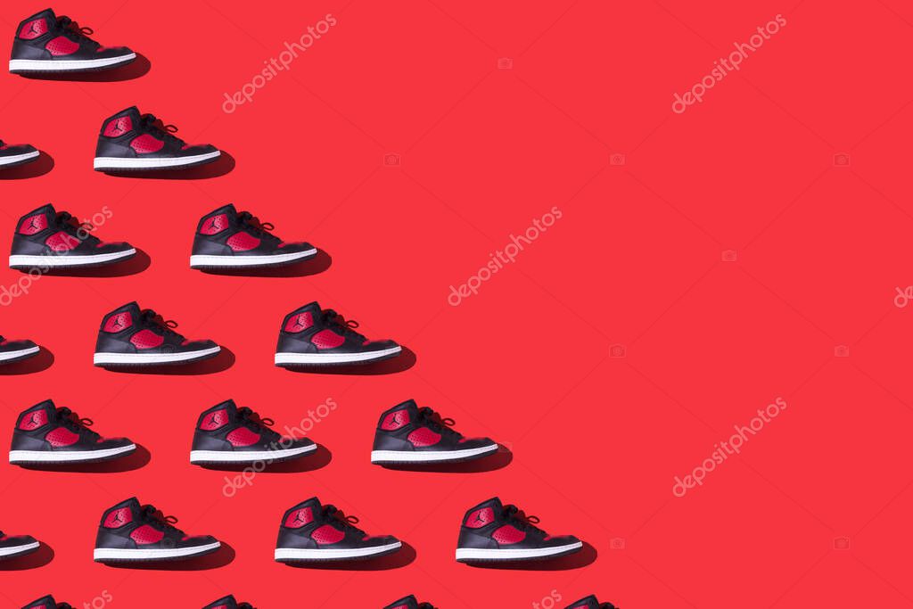 Pattern of NIKE Jordan Access sneakers in black and red, on the left side, on a red background. Concept of sneaker, basketball, retro, michael jordan, fashion, collection and casual