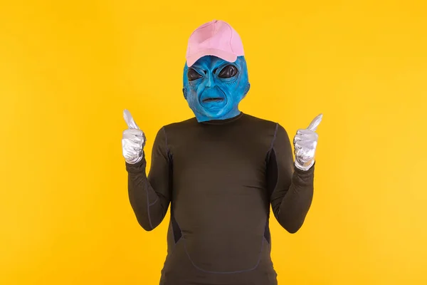 Człowiek Niebiesko Głowej Masce Kosmity Różowej Czapce Kciukami Górze Pojęcie — Zdjęcie stockowe