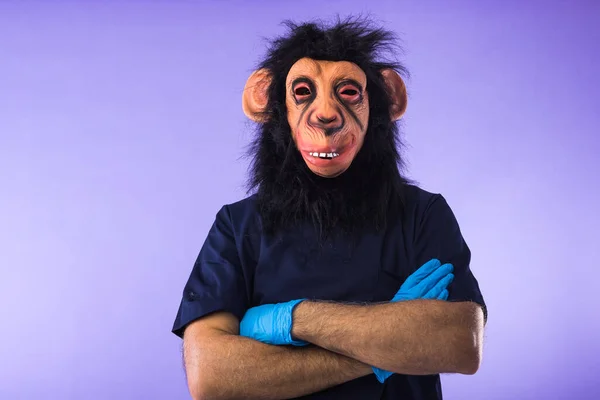 Zamaskowana Osoba Masce Małpy Stroju Lekarza Krzyżowanymi Ramionami Fioletowym Tle — Zdjęcie stockowe