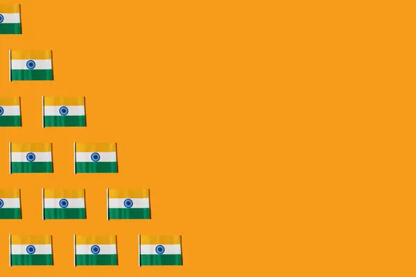 Pattern of flags of the Republic of India, on the left side, on orange background. Concept of Republic Day of India, January 26, Independence Day, August 15, celebration, orange, green, white.