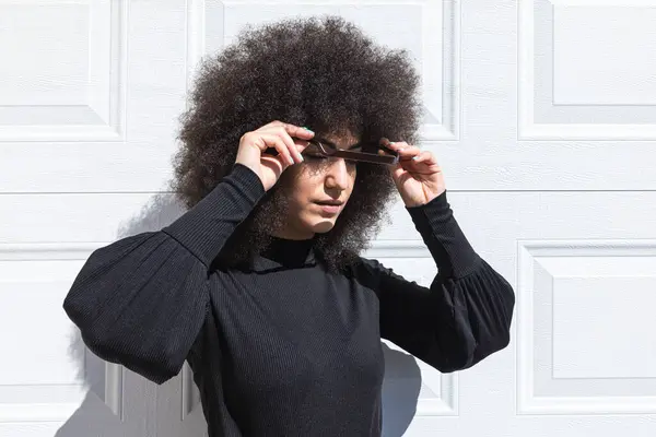 Młoda Biała Kobieta Afro Stylowymi Włosami Ubrana Czarno Opierająca Się Obrazy Stockowe bez tantiem