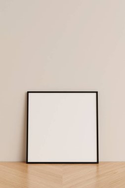 Clean and minimalist front view square black photo or poster frame mockup leaning against wall on wooden floor. 3d rendering. clipart