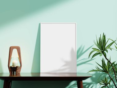 Nane yeşili bir arka fonda şık beyaz çerçeve, yanında ahşap bir mum tutacağı ve canlı bir yeşillik, sanatsal sunumlar için ideal..