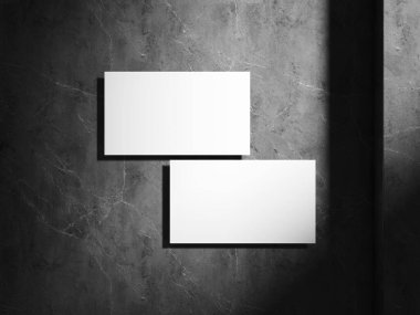 Profesyonel bir dokunuş için zıt ışık ve gölgeyle donatılmış modern, minimalist bir tarzda bir kartvizit gösteren yüksek kaliteli bir maket..