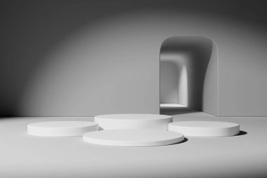 Tarafsız bir odada, yumuşak ışıklandırma ve kemerli bir kapı aralığı olan beyaz dairesel podyumlardan oluşan bir üçlü..