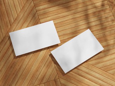 Ahşap zeminde iki kartvizit var. Keskin açılar ve profesyonel görünüm için yumuşak gölgeler var..