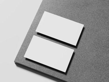 Zarif beyaz kartvizit, modern tasarımını geliştiren yumuşak gölgeli parlak mermer bir yüzeye yerleştirilmiş..