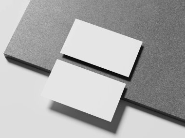 Pürüzsüz mermer bir yüzeye yerleştirilmiş bir çift basit beyaz kartvizit zarif bir sunum için ince bir gölge oluşturur..