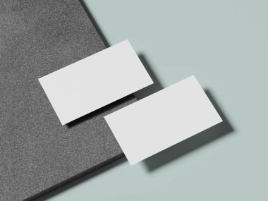 Pürüzsüz bir mermer yüzeyde duran beyaz kartvizitler taze ve minimalist bir görünüm veriyor..