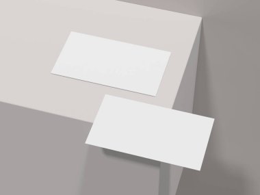 Masanın kenarındaki beyaz kartvizitlerin temiz bir modeli.