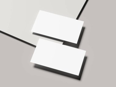 Açık gri arka planda keskin gölgesi olan bir çift kartvizit.