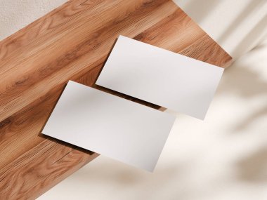 Tahta bir masada üst üste binen iki kartvizitin üst görüntüsü temiz bir estetik yaratıyor..