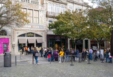 A line of people waiting to walk into the famous old Livraria Lello bookstore in Porto, Portugal, listed as the most beautiful bookstore in the world
