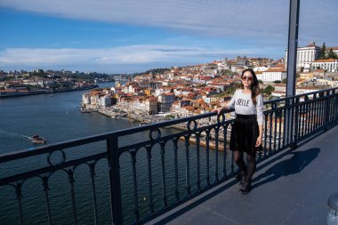 Dom Luis Köprüsü 'nde çizgili beyaz bir gömlekle dolaşan genç bir kadın. Fransızca 