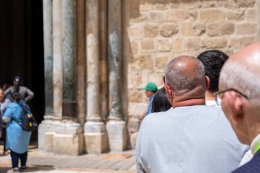 Kudüs, İsrail - 10 Nisan 2023. Turistler Kutsal Mezar Kilisesi 'ne girmek için kuyrukta bekliyorlar.