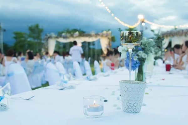 An overview of a romantic candle-lit wedding banquet and beautiful guests on the wedding banquet table.