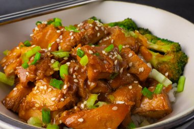 Lezzetli tavuk pirinci, susamlı tohumlar ve dilimlenmiş taze soğan brokoli, çubuklu sebzeler. Asya yemekleri, Japon yemekleri. Yakın çekim.