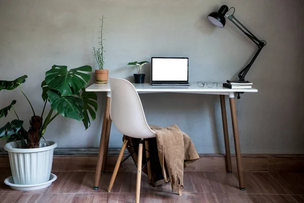 ノートパソコンのモックアップと椅子 ランプライトとモンスターツリーポット植物としてテーブルの装飾に眼鏡ドキュメントブックとホームオフィス家の自然壁近代的なロフトインテリア装飾ワークスペース — ストック写真