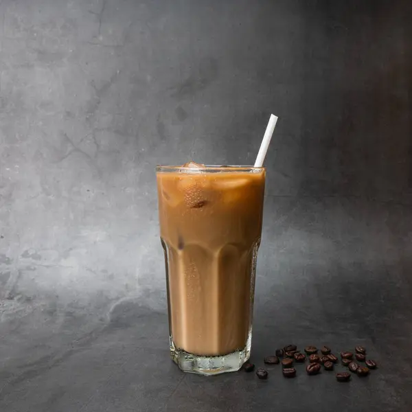 Iced coffee on cup with roasted coffee beans on a black background studio photo