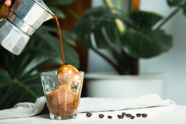 Ev yapımı Affogato, İtalyan Moka kahve demliği, affogato temel bileşen olarak kahvenin bir kepçe dondurma ya da vanilyalı dondurmayı bir fincana doldurduğu tatlıdır. O zaman bir bardak sıcak espresso koy..