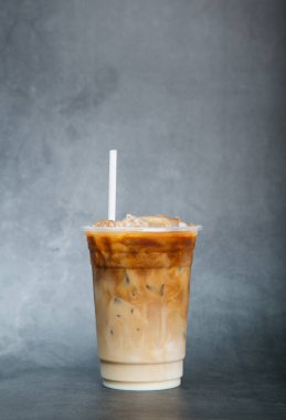 Asya buzlu kahvesi plastik bardakta siyah mermer üzerinde dikey fotoğraf stüdyo arka planında yaz içkisi konsepti.