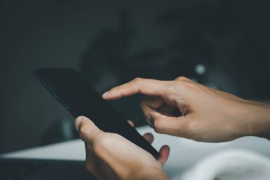 Çevrimiçi internet alışverişi ya da e-ticaret yoluyla cep telefonu akıllı telefonuna dokunan el adamı, cihaz telefonuyla dünya çapında sosyal medya interneti araştırıyor.