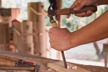 Marangozluk atölyesi mobilya projesinde çalışan ahşap ürün üzerine oyulmuş aletleri kullanan bir marangoz. 