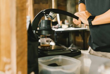 Flair Espresso Maker kullanan bir barista kol ya da kol kullanan elektriksiz kahve demleme cihazıdır. Kahve ve buzlu kahve yapan bir masaya espresso dökmek için. yumuşak odak