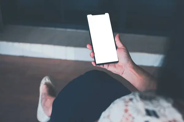Kezében Egy Okostelefon Fehér Képernyős Modell Egy Széken Nappaliban Otthon Stock Fotó