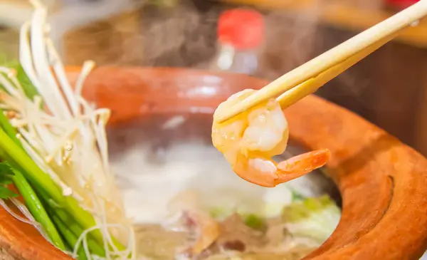 샤브샤브 따뜻한 냄비를 뜨거운 새우의 젓가락과 음식을 로열티 프리 스톡 이미지