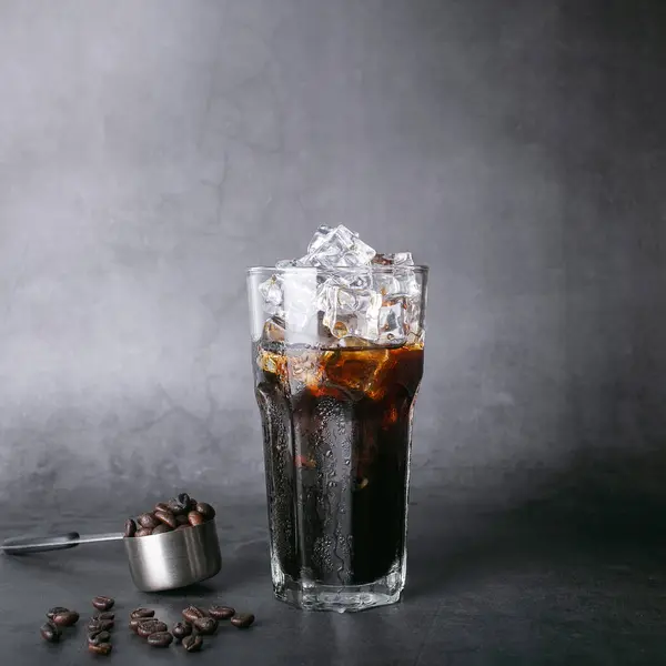 Americano Eiskaffee Menükaffee Und Geröstete Bohnen Kaffee Einem Quadratischen Löffel lizenzfreie Stockfotos