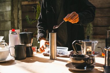 Asyalı Barista 'nın kahvesini hazırlayıp bardağa sıcak kahve damlatması, mutfak evinde demlenen aletler. kahve deneyimi