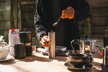 Asyalı Barista 'nın kahvesini hazırlayıp bardağa sıcak kahve damlatması, mutfak evinde demlenen aletler. kahve deneyimi