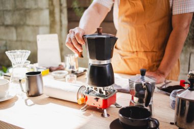 In the cozy cafe, the barista skillfully brews fresh coffee using a moka pot, creating a rich, aromatic experience for patrons. Preparation drink clipart