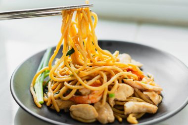 Lezzetli Tayland fesleğenli tavuk kızartması. Yemek çubuklarıyla birlikte paslanmaz tabakta servis ediliyor. Öğle veya akşam yemeği için ev yapımı Asya mutfağı. Metnin için boşluk kopyala